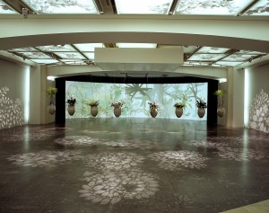 Duża przestrzeń wystawiennicza z licznymi świetlikami w suficie. Na środku sali zawieszono donice z roślinami, które sprawiają wrażenie, jakby lewitowały.